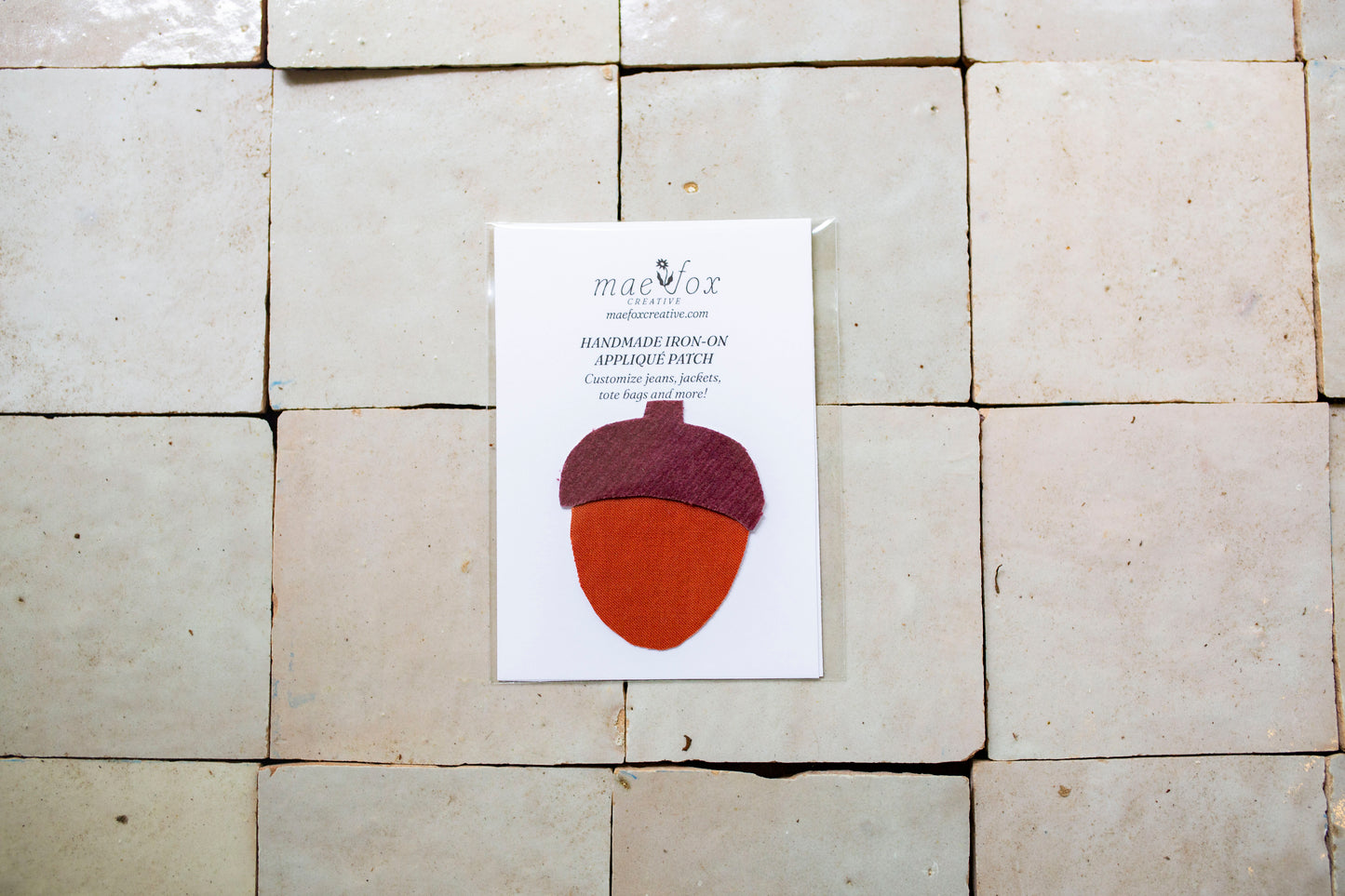 Handmade appliqué patch shaped like an acorn, crafted from mixed vintage fabrics slightly imperfect, charming handmade finish, designed for decorating jackets, jeans, or tote bags.