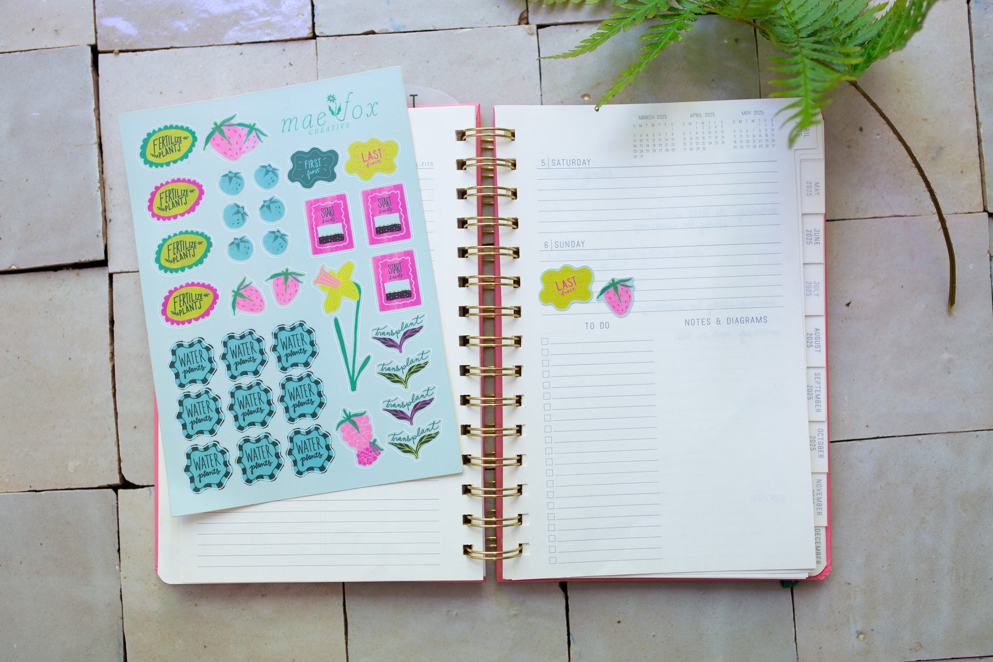 Open planner with stickers on a tile surface