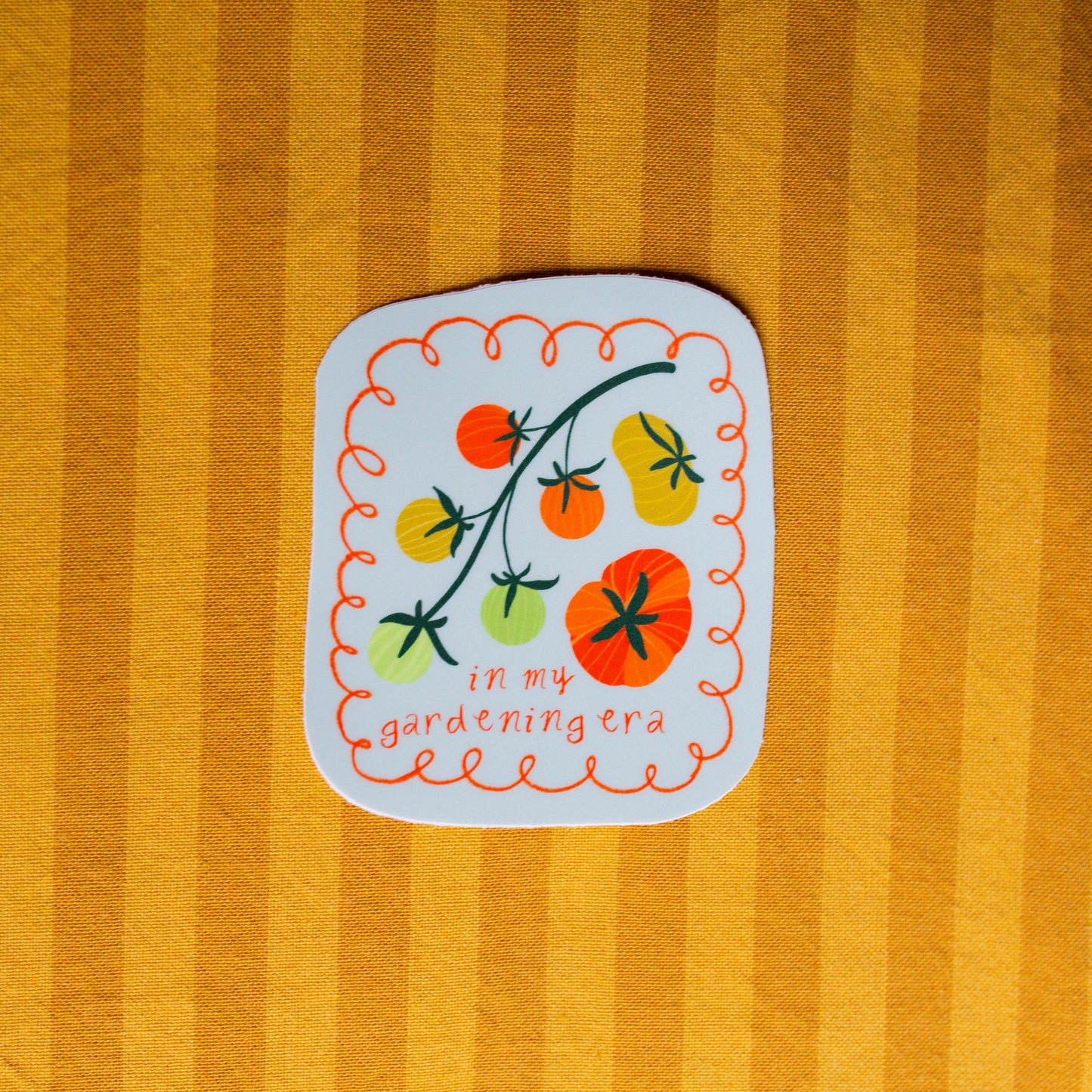 Sticker with tomato design on a striped yellow background