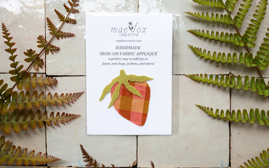 Handmade strawberry-shaped appliqué patch in pink and mustard gingham fabric with green leaf details