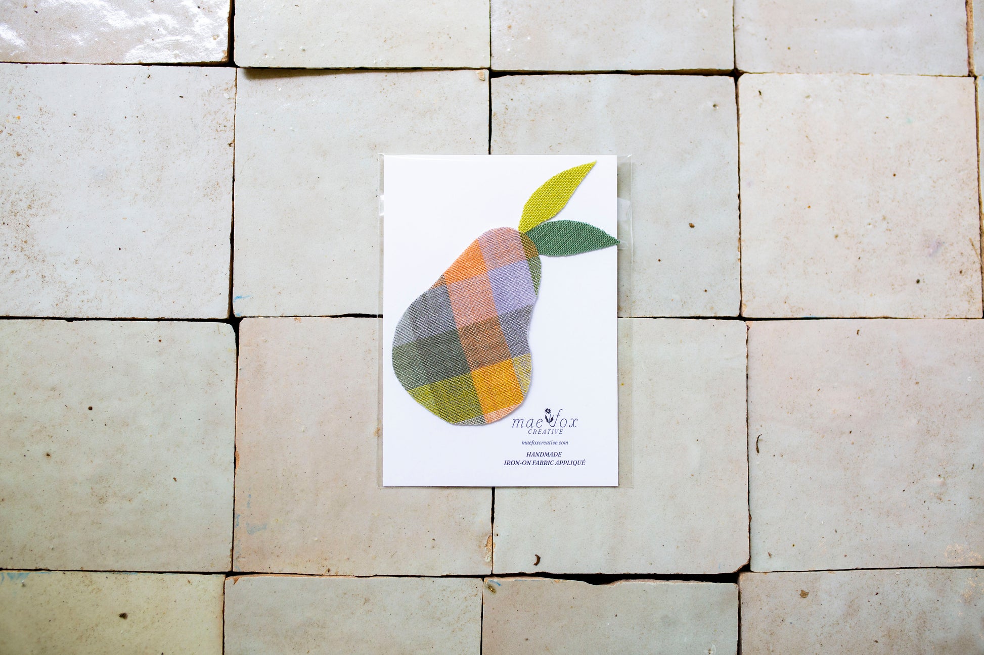 Handmade appliqué patch shaped like pear, crafted from vintage and scrap fabric, slightly imperfect, charming handmade finish, designed for decorating jackets, jeans, or tote bags.