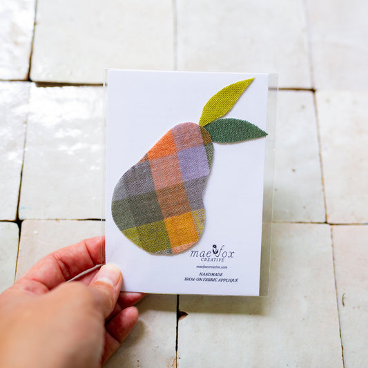 Handmade appliqué patch shaped like pear, crafted from vintage and scrap fabric, slightly imperfect, charming handmade finish, designed for decorating jackets, jeans, or tote bags.