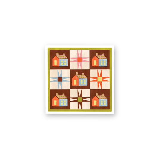 Framed quilt with geometric pattern of houses and stars on a white background