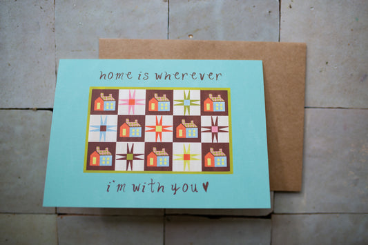 Card with quilt design and text 'home is wherever I'm with you' on a tile surface