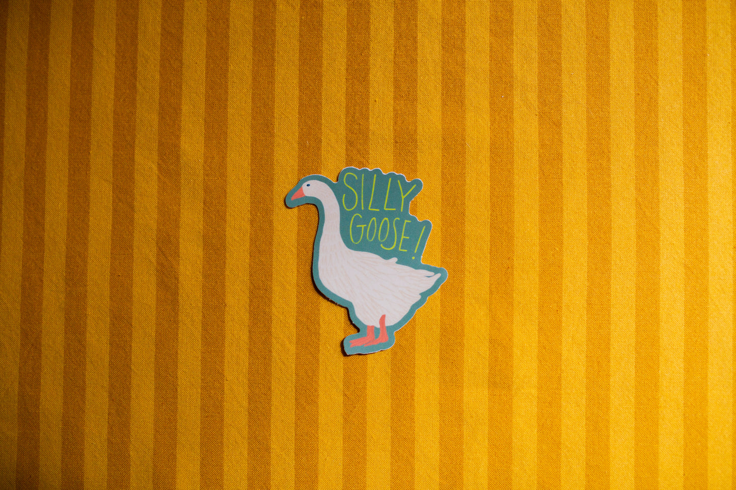 Sticker of a goose with 'Silly Goose' text on a yellow striped background