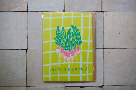 Greeting card with a bunch of radishes that say "Thanks a Bunch" On a bright green background with light blue grid pattern