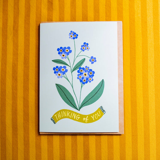 Card with floral design and 'Thinking of You' text on a yellow striped background