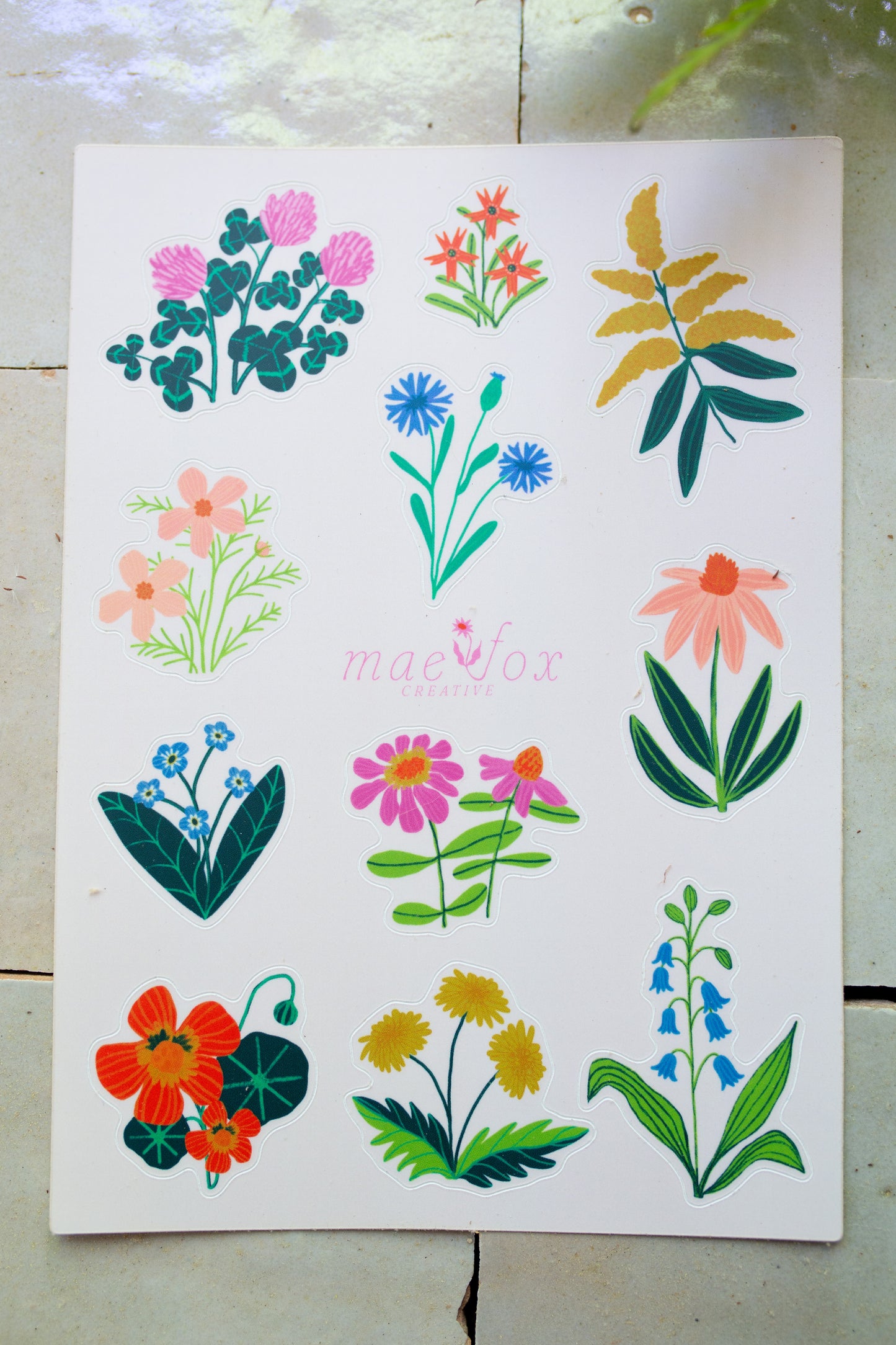 Sheet of wildflower stickers with various designs on an off white background.