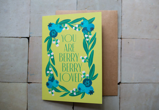 Card with blueberries on a yellow background that has words that say "You Are Berry Berry Loved"