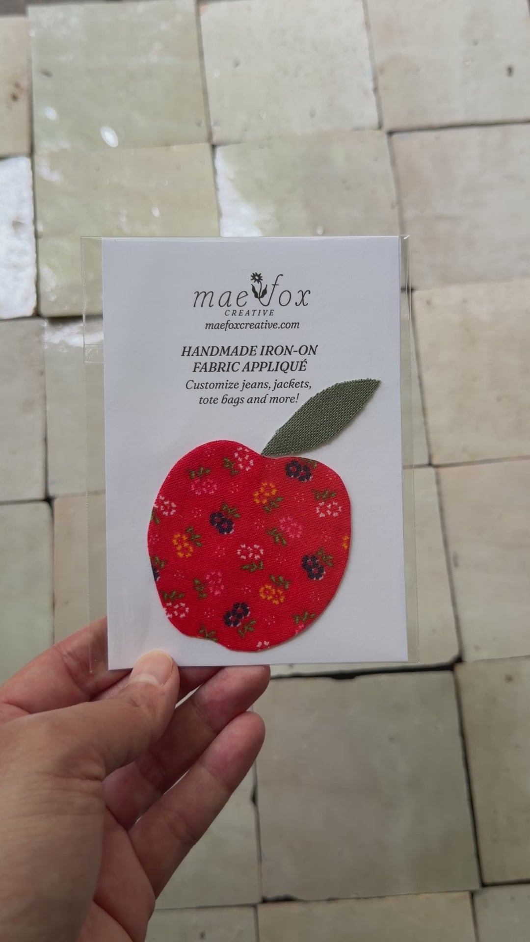 Handmade appliqué patch shaped like a apple, crafted from mixed vintage fabrics in rich red tones with a textured green leaf top, slightly imperfect, charming handmade finish, designed for decorating jackets, jeans, or tote bags.