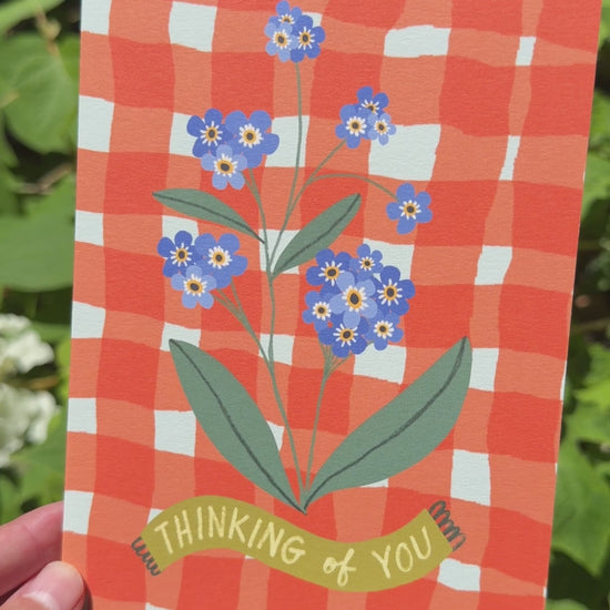 Video of a card that says Thinking of You with Forget Me Not Flowers on a Red Gingham Background
