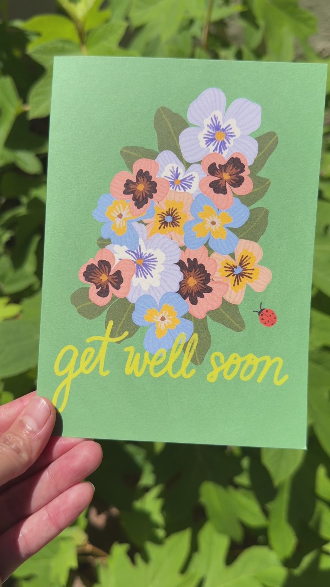 Video of a card that says get well soon with a pansies and a lady bug on a green background
