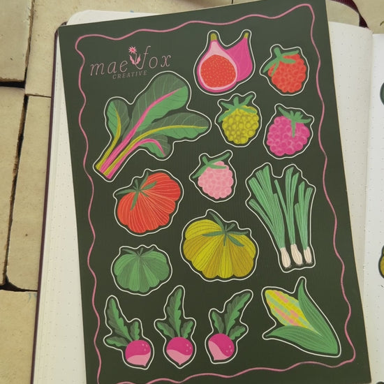 video of sticker sheets that are 5x7 dark green background with Swiss chard, heirloom tomatoes, and raspberries.