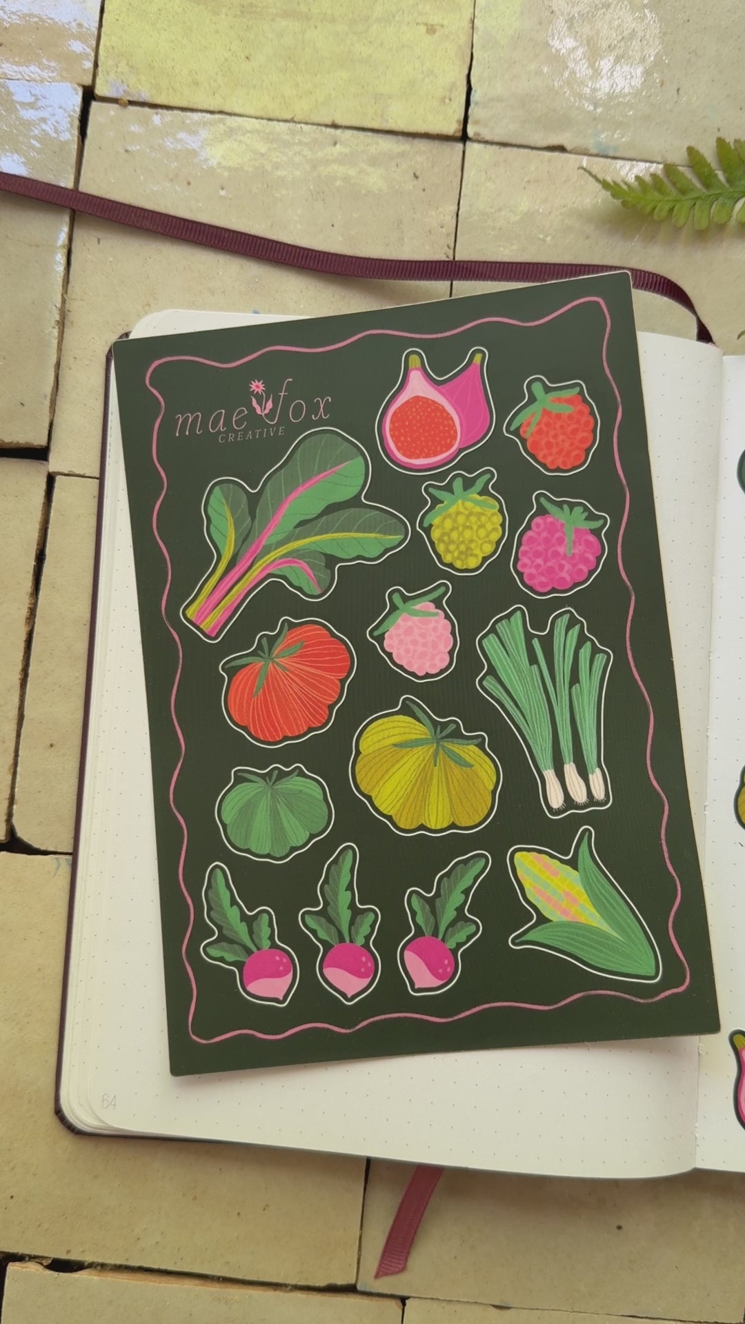 video of sticker sheets that are 5x7 dark green background with Swiss chard, heirloom tomatoes, and raspberries.